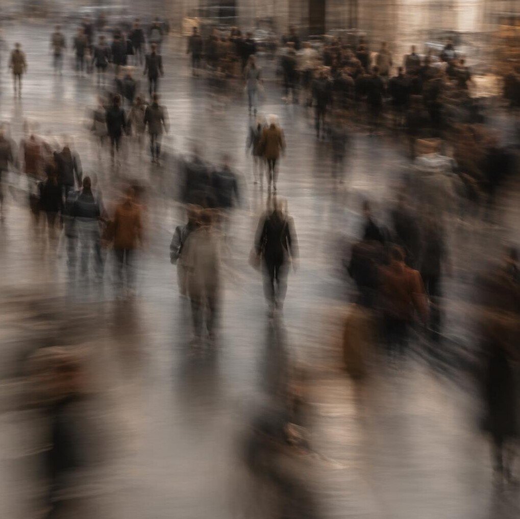 Blurred silhouettes of a crowd of people in motion