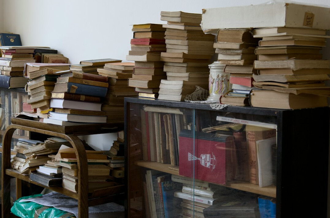 Rows of stacked archival journals and old books